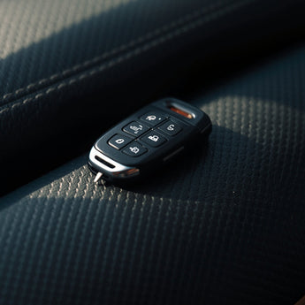 Black Garage Door Remote Control on Black Leather Car Interior