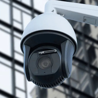 white cctv ptz camera with mount outside cityscape
