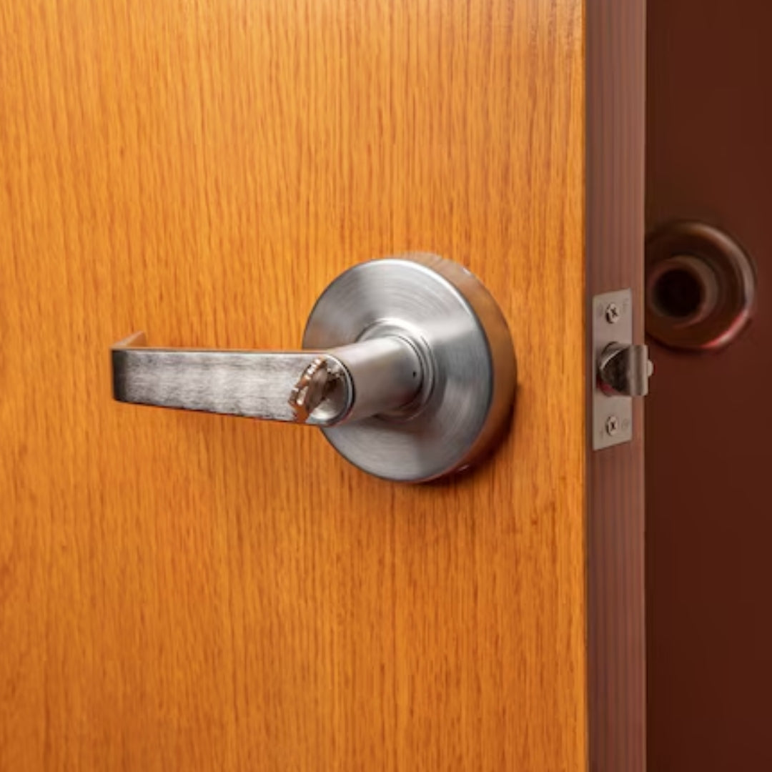 silver storeroom lock on wooden door with door stopper behind