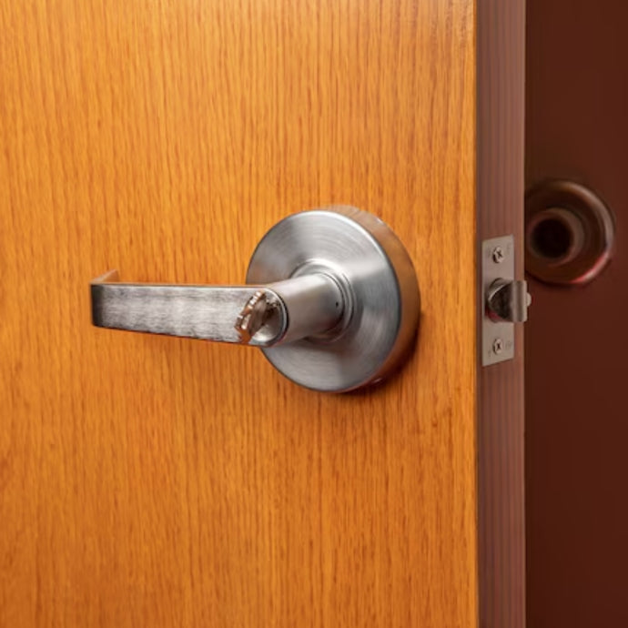 silver storeroom lock on wooden door with door stopper behind
